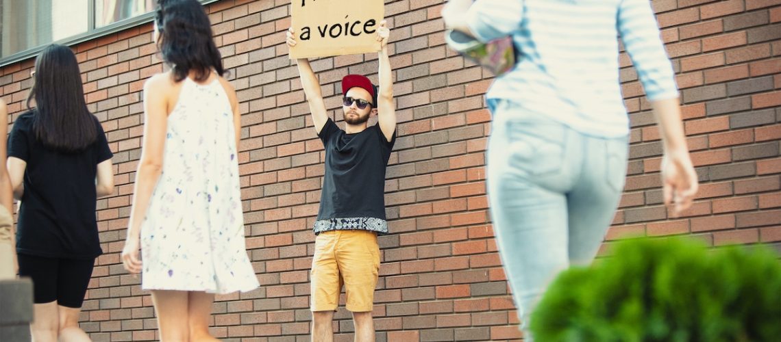 I have a voice. Dude with sign - man stands protesting things that annoy him. Solo demonstration his right to talk free on the street with sign. Opinion heard by public. Social life, politics