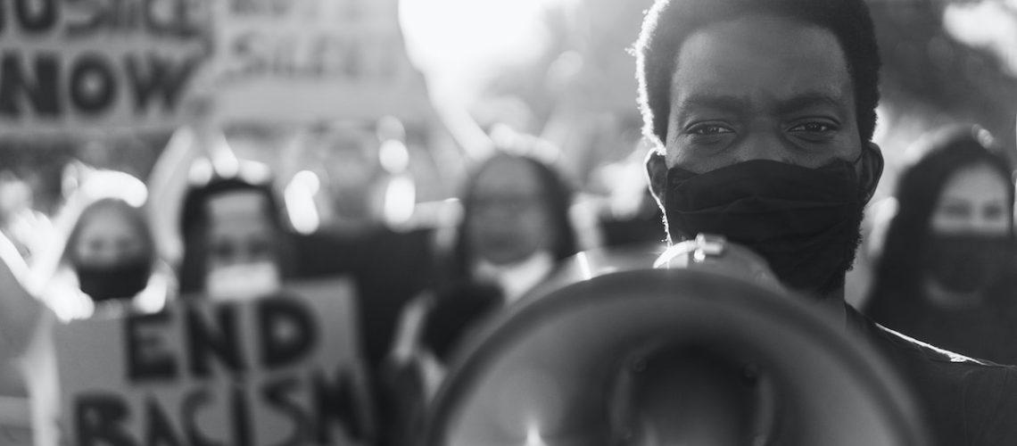 People from different culture and races protest on the street for equal rights - Focus on black man eyes