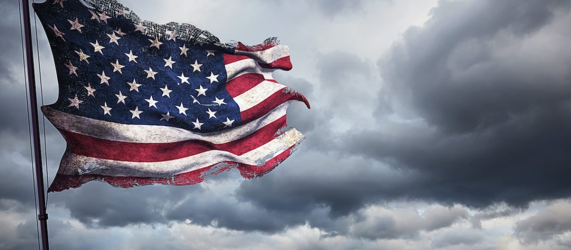 ripped tear grunge old closeup of american USA flag, stars and stripes, united states of america on cloudy sky, dark mystery style atmosphere